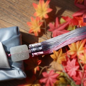 a box wrapped with blue grey color Bojagi and pink&lavender Norigae is hung on it.