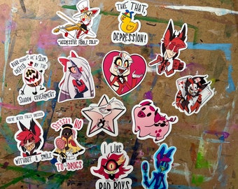May include: A set of 11 stickers featuring cartoon characters from the animated series "Hazbin Hotel". The stickers are printed on white paper with a glossy finish. The characters include: a red-haired demon with horns, a pig, a yellow duck, a star, a demon with a fiddle, a demon with a lollipop, a demon with a heart, a demon with cards, a demon with a microphone, and a demon with a crown.