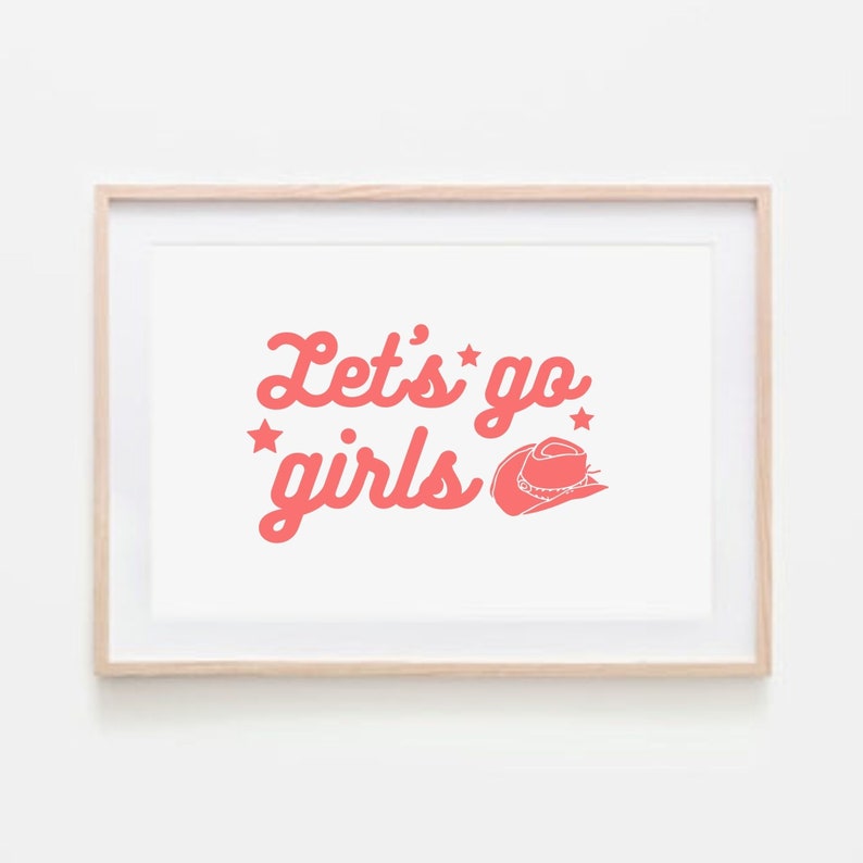 May include: A framed print with the text "Let's go girls" in pink lettering with a pink cowboy hat graphic. The print is in a light wood frame.