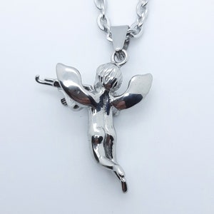 Pu&ograve; includere: Collana con catena d'argento con un ciondolo a forma di cherubino che tiene un arco e una freccia. Il cherubino &egrave; dettagliato e ha le ali.