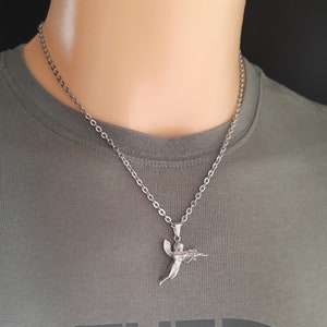 Pu&ograve; includere: Una collana a catena d'argento con un ciondolo a forma di angelo d'argento che tiene una pistola. L'angelo sta volando con le ali spiegate.