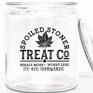 May include: A clear glass jar with a black and white label that reads "Spoiled Stoner Treat Co. Inhale More. Worry Less. It's 4:20 Somewhere". The label features a maple leaf design.