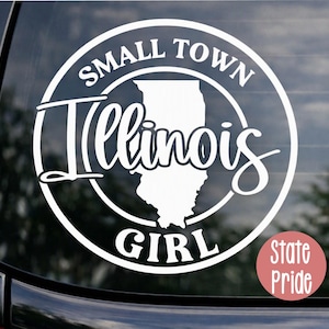 May include: A white circular vinyl decal featuring the text SMALL TOWN at the top and GIRL at the bottom, with the word Illinois written in a cursive script across the center, overlaid on a silhouette map of the state of Illinois.
