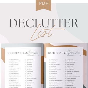 May include: A printable decluttering list with the title "100 Items to Declutter" in a brown and white book. The book is open to two pages with a list of items to declutter on each page. The book is on a white surface with a cup of coffee and a potted plant on either side.