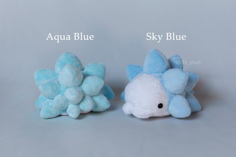 Puede incluir: Dos peluches con forma de criatura azul y espinosa. El peluche de la izquierda es azul aguamarina y el de la derecha es azul cielo. El texto "Aqua Blue" est&aacute; encima del peluche de la izquierda y el texto "Sky Blue" est&aacute; encima del peluche de la derecha. El texto "@chi_plush" est&aacute; debajo del peluche de la derecha.