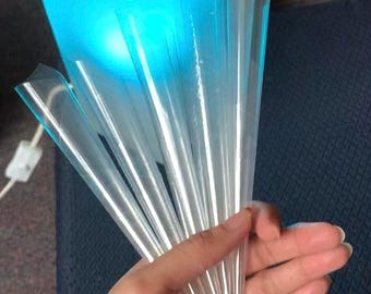 May include: A set of clear plastic cones, some with colorful beads at the tip, are held in a hand. The cones are arranged in a fan shape.