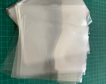 May include: A stack of clear plastic sleeves, likely for protecting documents or photographs.
