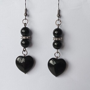 May include: Black heart shaped earrings with black beads and silver accents.