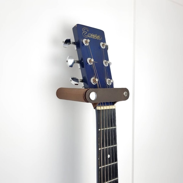 Soporte de pared para guitarra de nogal y cuero.