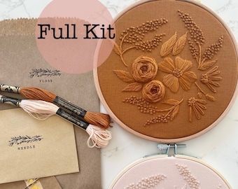 May include: Full embroidery kit with two embroidery hoops, one with a floral design in shades of orange and brown, and the other with a floral design in shades of pink. The kit also includes embroidery floss and a needle.