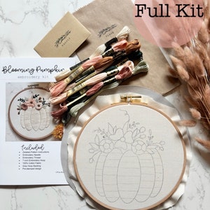 May include: A complete embroidery kit for a blooming pumpkin design. The kit includes a 7-inch embroidery hoop, pre-stamped fabric, embroidery floss, a needle, and instructions.