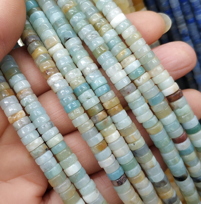 May include: A strand of light blue, green, and brown gemstone beads. The beads are round and have a smooth, polished finish.