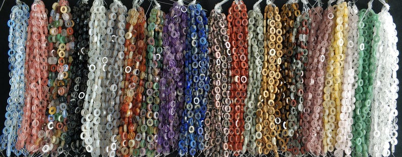 Puede incluir: Surtido de 20 hilos de cuentas de piedras preciosas, cada hilo presenta un color y tipo de piedra diferente. Las cuentas son peque&ntilde;as y redondas con un agujero en el centro, perfectas para la elaboraci&oacute;n de joyas.