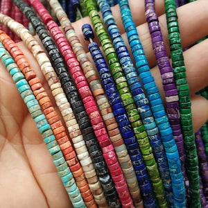 May include: Assortment of colourful, round, gemstone beads with a speckled pattern. The beads are strung on a string and are arranged in a row.