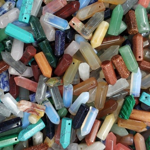 May include: A collection of colorful gemstone pendants in various shapes and sizes. The pendants are made of natural stones and have a polished finish. They are perfect for jewelry making or crafting.