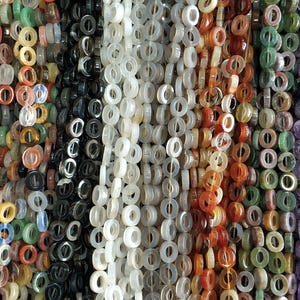 Puede incluir: Surtido de cuentas de piedras preciosas de colores en varios tonos de rosa, verde, blanco, rojo, morado y azul. Las cuentas son todas redondas y tienen un agujero en el centro, lo que las hace adecuadas para la elaboraci&oacute;n de joyas.