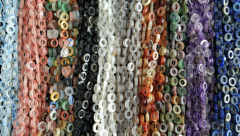 Puede incluir: Surtido de cuentas de piedras preciosas de colores en varios tonos de rosa, verde, blanco, rojo, morado y azul. Las cuentas son todas redondas y tienen un agujero en el centro, lo que las hace adecuadas para la elaboraci&oacute;n de joyas.