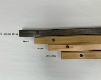以下が含まれることがあります： 上から下へ、4つの木材サンプル：パイン-ステンドエボニー、ポプラ、メープル、ホワイトオーク。各サンプルの中央には黒い金属製のネジがあります。