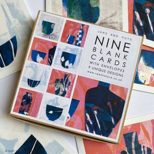 May include: A box of nine blank cards with envelopes. The cards feature unique designs of blue and pink jars and pots. The box has the text "Jars and Pots Nine Blank Cards with Envelopes 9 Unique Designs www.rawmixture.co.uk".