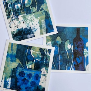 May include: Three abstract art prints in shades of blue, green and white. The prints feature different patterns and designs, including a bottle shape and floral motifs.