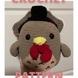 May include: Crochet pattern for a brown and red turkey amigurumi with a black top hat. The pattern is not a physical item.  @katiebeingcreative