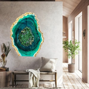 May include: A green and gold resin art piece with a swirling pattern resembling a geode. The art piece is mounted on a wall in a modern home interior.