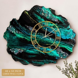May include: Large wall clock, 42 x 33 inches, with a unique, organic shape. The clock face is gold-colored with Roman numerals. The background features a swirling pattern of black, teal, and green resin with glitter accents.