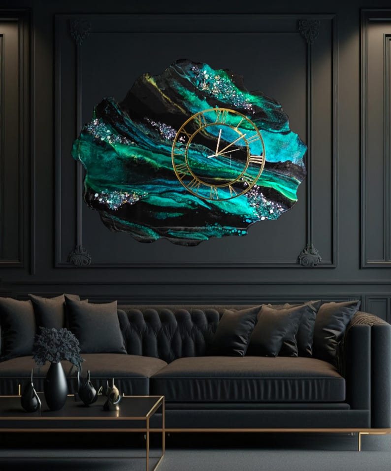 May include: A large, abstract wall clock with a gold-colored frame and Roman numerals. The clock face is set against a backdrop of swirling teal, black, and silver resin. The clock is mounted on a dark wall above a black sofa.