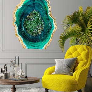 May include: A large, abstract wall art piece featuring a green and gold agate design. The agate is a circular shape with a swirling pattern of green and gold.