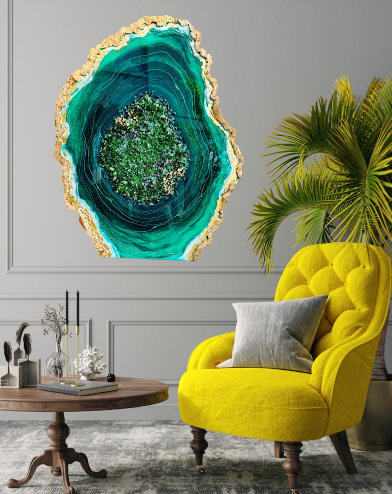 May include: A large, abstract wall art piece featuring a green and gold agate design. The agate is a circular shape with a swirling pattern of green and gold.