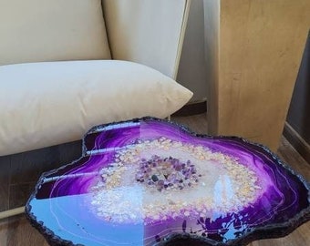 May include: Purple resin coffee table with gold metal legs and a geode design with amethyst crystals.