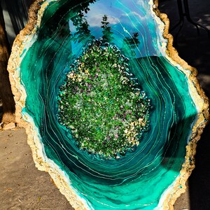 May include: A large, round, green and gold resin art piece with a swirling pattern and a center filled with green and purple glitter.