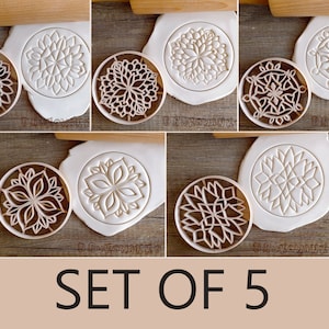 May include: Set of five cookie cutters with intricate mandala designs. The cutters are made of brown plastic and are shown on a white surface. The text "SET OF 5" is printed below the cutters.