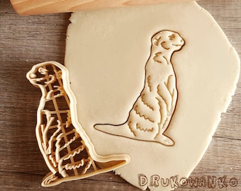 Suricata de pie sobre un reloj, mamífero africano, película popular, animación, mangosta, niños, dibujos animados, animal, cortador de galletas, pastelería, fondant, masa, galleta