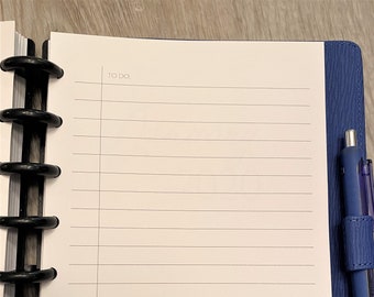 May include: A blue notebook with a black coil binding and a pen. The notebook has lined pages and the words "TO DO:" printed at the top of the page.