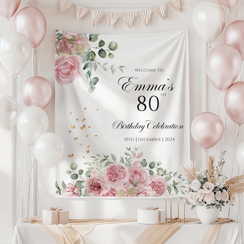 May include: White backdrop with pink floral design and gold glitter. Text reads "Welcome to Emma's 80th Birthday Celebration 10th December 2024".