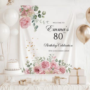 May include: White backdrop with pink floral design and gold glitter. Text reads "Welcome to Emma's 80th Birthday Celebration 10th December 2024".
