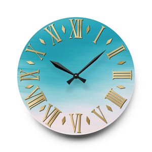 May include: A round wall clock with a blue and white ombre background. The clock face has Roman numeral markings in gold and black hands.