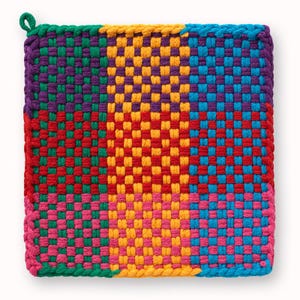May include: Square, woven hot pad in a patchwork design. The pad features a vibrant mix of colors, including red, yellow, green, purple, pink, and blue. A loop is attached to one corner for hanging. The dimensions are approximately 8 inches by 8 inches.