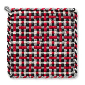 May include: Square woven hot pad with a loop for hanging. The pattern is a grid of red, black, gray, and off-white squares. The edges are finished with a gray and white braided trim.