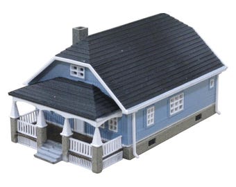 May include: A blue and white model house with a porch and a black roof. The house has a chimney and several windows.