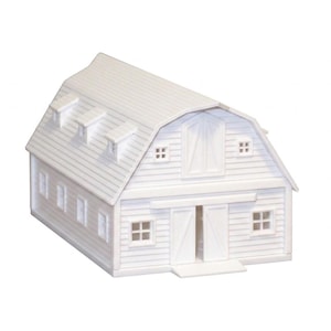 May include: A white miniature barn model featuring a gambrel roof, three small dormer windows on the roof slope, horizontal siding, a central double door entrance, and several small square windows on the front and side walls of the structure.