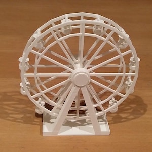 May include: A white miniature Ferris wheel with a detailed design and multiple seats. The wheel is on a white base.