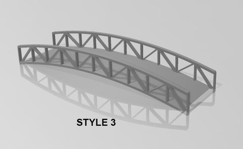 May include: A gray metal bridge with a truss design. The bridge has a curved arch and a flat deck. The bridge is made of metal bars that are connected together to form a strong structure. The bridge is a simple design that is perfect for adding a touch of realism to any model railroad layout.