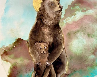 May include: A watercolour painting of a brown bear and a cub. The bear is standing tall with a halo of gold paint above its head. The cub is nestled in the bear's arms. The background is a soft blue and green watercolour wash.