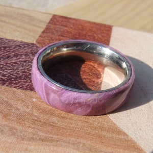 May include: A purple and silver wood ring with a stainless steel band.
