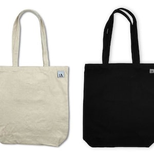 May include: Two tote bags, one beige and one black, both with a small black logo that says "SA".