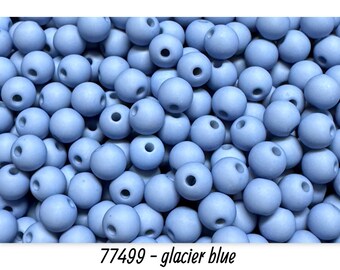 May include: A close-up shot of a pile of light blue, round beads. Each bead has a hole through the center. The text "77499 - glacier blue" is at the bottom of the image. These beads are suitable for jewelry making.