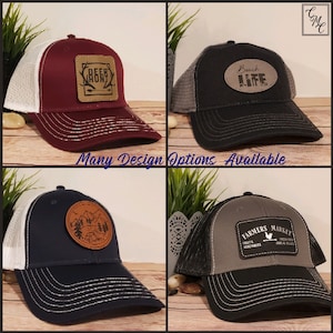 May include: Four different trucker hats with various embroidered patches. The patches feature designs such as "Deer Hunt", "Beach Life", a mountain scene, and "Farmers Market".