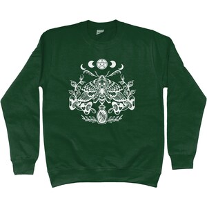 May include: A dark green sweatshirt with a white graphic print of a moth, a pentagram, and crescent moons. The moth is surrounded by leaves and a bottle with a cork.